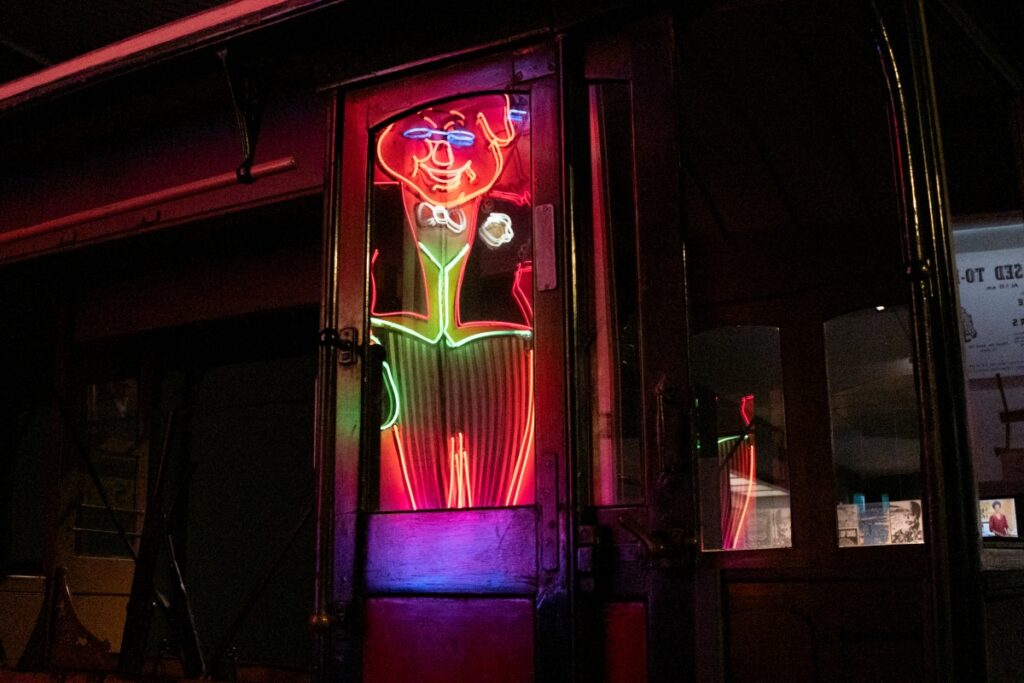 Reflection of a butcher's neon sign at Toitū Otago Settlers Museum